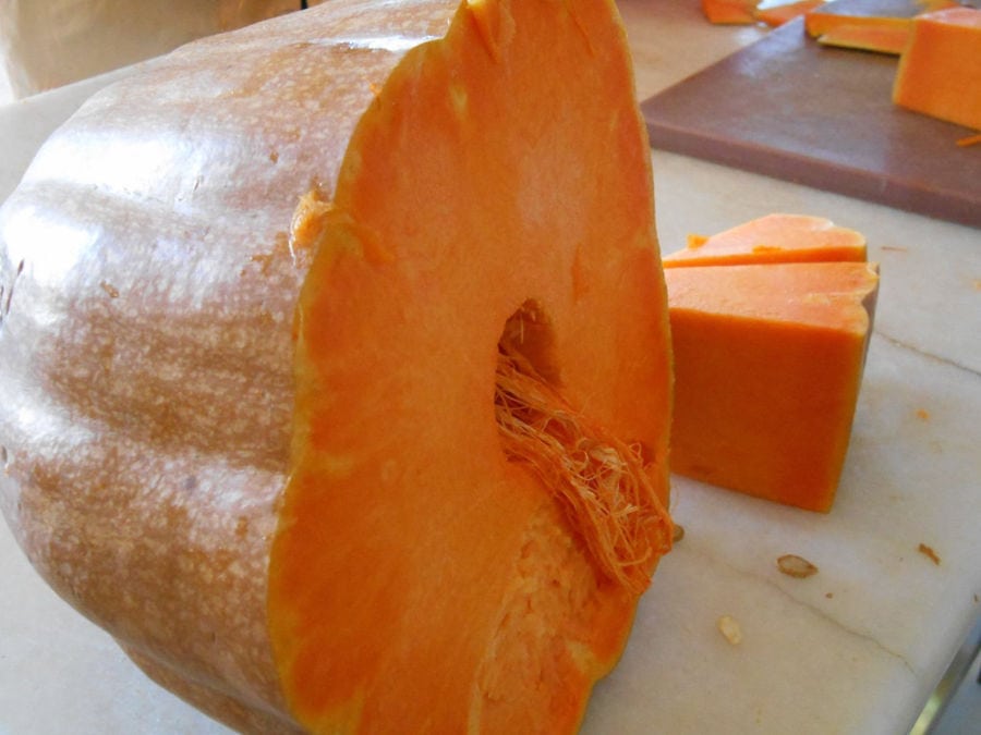 close-up of cutting yellow pumpkin in half at 'Agrotouristic Women's Cooperative of Mesotopos Lesvos'